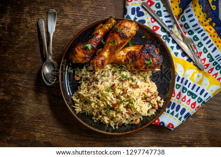 African cuisine grilled chicken legs with jollof rice with orzo and black eyed peas Royalty-Free Stock Photo #1297747738
