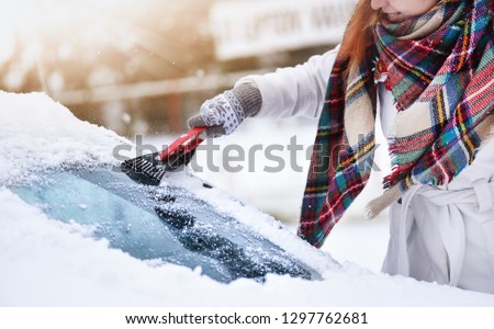 Cleaning snow from windshield, Scraping frozen ice, Winter car front windows clean. Royalty-Free Stock Photo #1297762681