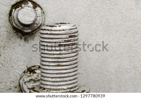 big bolt and nut closeup. Metal construction and threaded connection. Gray background. The basis of the iron electricity pylon.