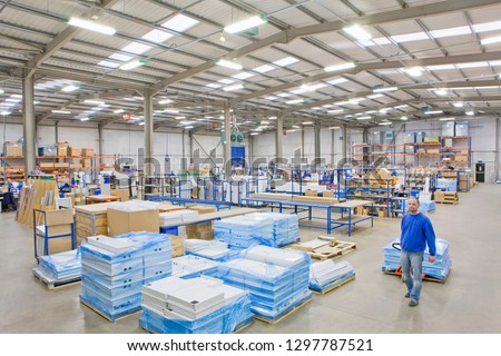 Distribution warehouse worker pulling boxes on pallet truck