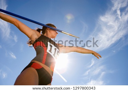 Female athlete preparing to throw javelin in athletics competition Royalty-Free Stock Photo #1297800343