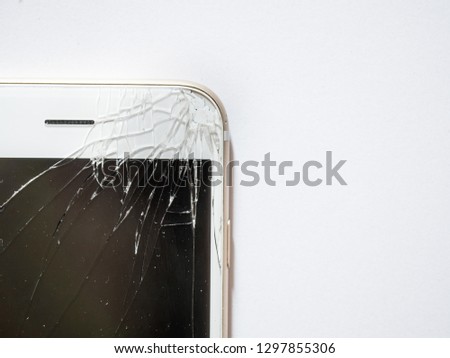 Close up of broken glass and cracked display or screen of mobile phone or smartphone on white background.