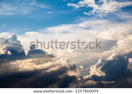 Sunbeams among the clouds in the blue sky