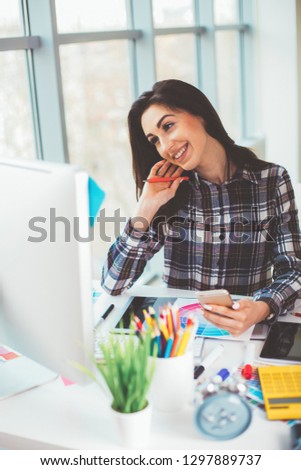 pretty designer looking at the camera using digitizer in creative office