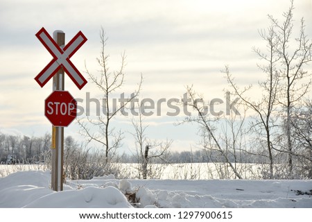 An image of a bright red stop sign at a train crossing.
