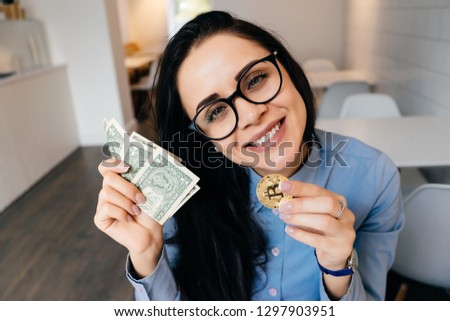 happy girl with glasses in her hands holds a crypto currency