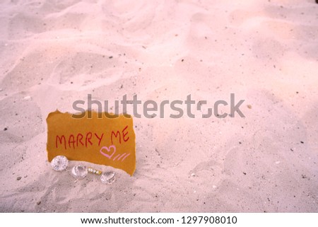 marry me message on the beach   with diamond ring