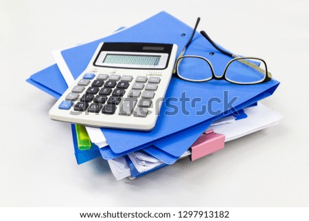Blue file folder with paper, glasses, calculation on the table in work office room, Business concept.