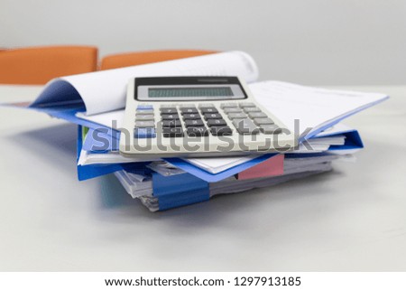 Blue file folder with paper, calculation on the table in work office room, Business concept.