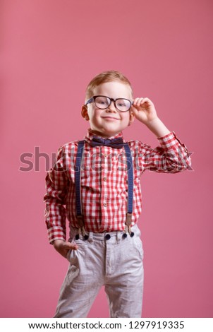 Portrait of stylish little boy. Little child in glasses has idea. Kid isolated on pink blackboard. Success, bright idea, creative ideas and innovation technology concept.
