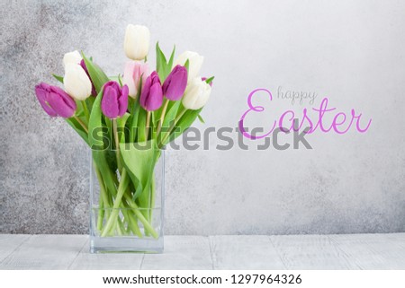 Easter greeting card with tulip flowers bouquet. In front of stone wall with space for your greetings