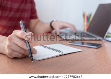 Business people at workplace Think business investment plan.Contact Investor using cell phone,computer make note meeting of appointment information in the notebook.design creative work space