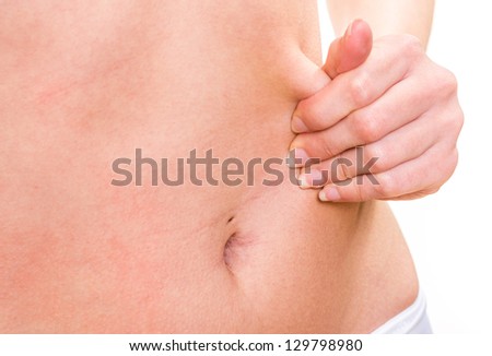 female pinching skin of her belly