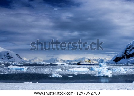 Cruise ship situated in a bay in Antarctica on a cloudy day