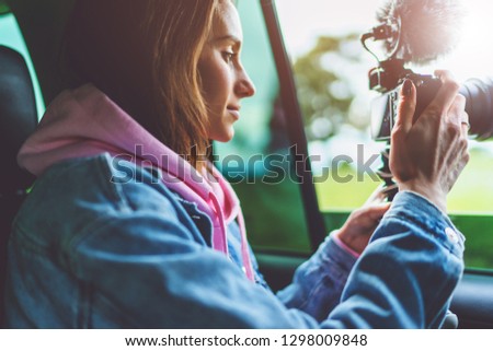 smile tourist girl in an open window of a auto car taking photography click on digital photo camera, photographer looking on camera technology, blogger using hobby content concept, enjoy trip