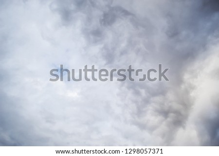 Blue sky peaking showing through dense gray clouds cloudy weather texture background can be used for sky replacement