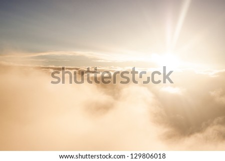 Sunrise above clouds during a flight bright light and colors Royalty-Free Stock Photo #129806018