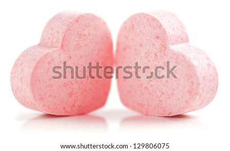 Sweet hearts shaped pink Sugar Pills on white background. Soft Focus.