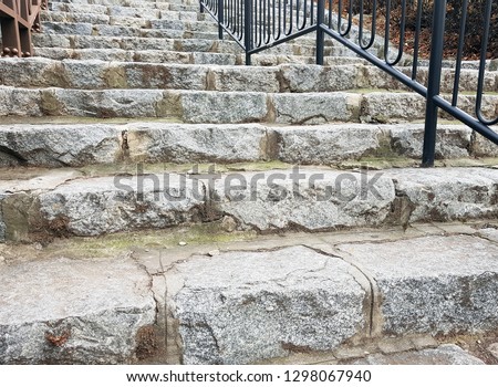 Close-up of partial of the old dirty rough stone stairs with the black steel barrier. Stairs-to-Success theme backdrop background.