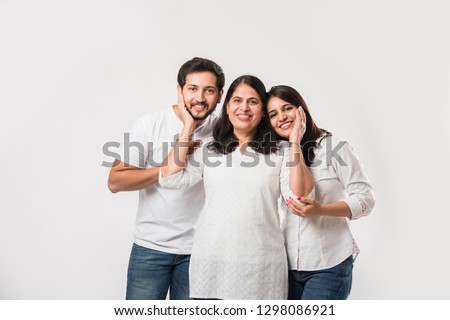 Indian old Mother embarrassing  young adult kids. Asian family of 3 standing isolated over white background. selective focus Royalty-Free Stock Photo #1298086921