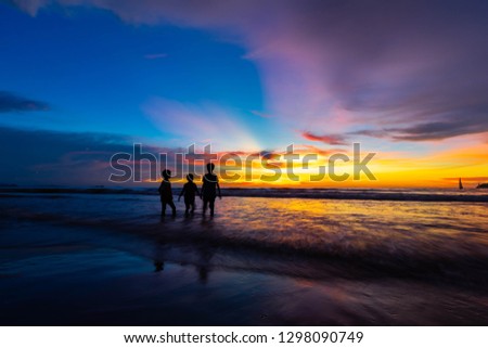 three siblings at a beach in Sabah sight during colourful sunset