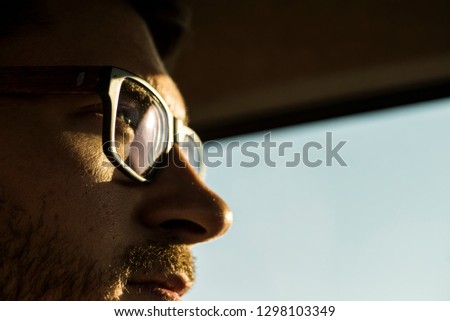 a face of a man with eye glasses looking out in the sun with determination Royalty-Free Stock Photo #1298103349