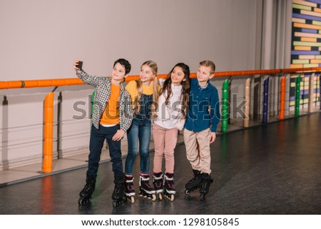 Little boy making selfie with friends while skating together
