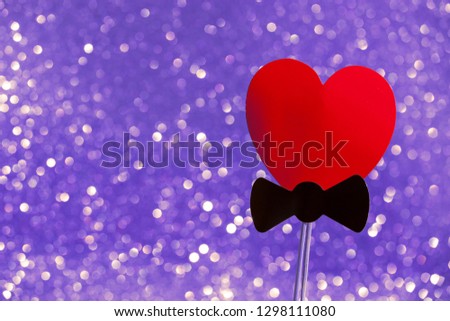 Red heart on a golden background with a shining golden glitter effect. Holiday card. Carnival. Mardi gras. Masquerade. Place for text. Valentine's Day. The concept of the holiday Purim. photo booth.