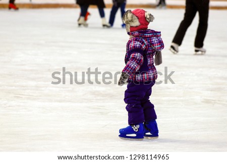 Children s skate ice rink. A little boy skates in the winter. Active family sport. School sports clubs, entertainment for children on winter holidays,  New Year,outdoor   