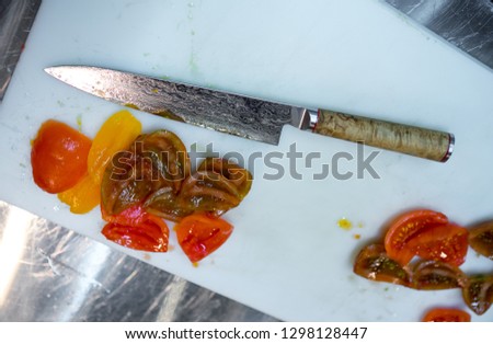 Chef. A restaurant. Cutting tomatoes with a kitchen knife.