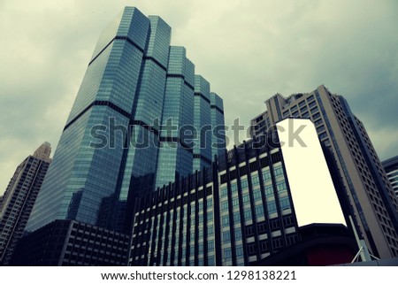 Blank advertising billboard on the Glass wall in a modern office building, Common business skyscrapers, high-rise buildings, architecture raising to the sky, the sun light reflected on the structure