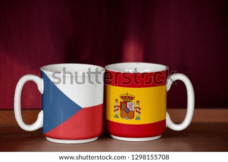 Spain and Czech Republic flag on two cups with blurry background