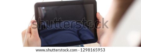 Male arms with pc pad wired to headphones at home closeup. Stock market trade and investment interactive data search use wifi connection wireless ip telephony inspiration idea web surf social network