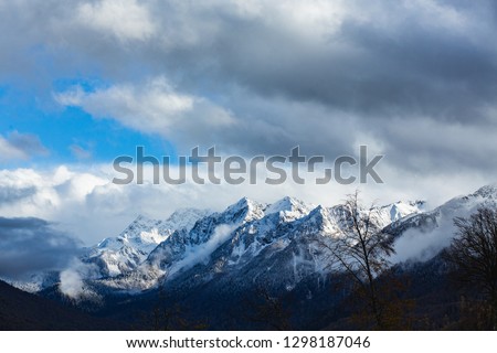 View of a beautiful mountain shrouded in blue clouds and a forest growing all over. Concept of atmospheric cyclone and anticyclone. Type of weather and environmental disaster