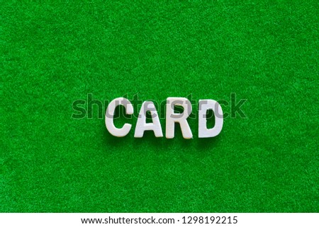Wooden text on short grass field concept. The word "CARD" on green background.