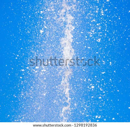 Splashes of water against the blue sky .
