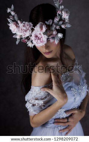 Fashion Portrait of Young Woman with Beautiful Flower Wreath Hairstyle and Fashion creative Makeup. Model with silk Blooming flower crown. Beauty salon background. Fairy tale magic lady.