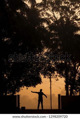 This photo represents a morning.A man gets up early in the morning and stands on a road.