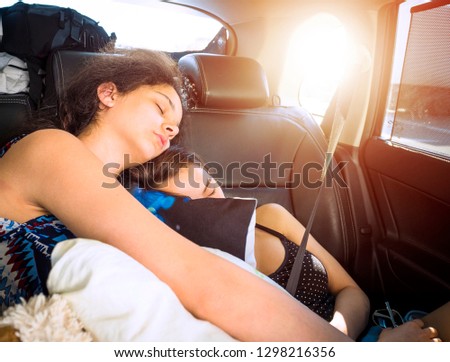 Two sisters teen sleeping on backseats of car while having trip.Vintage Style Picture