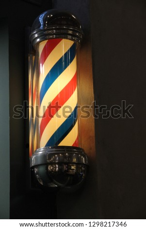 closeup of barber shop pole sign With blue and red moving stripes