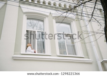 Young woman sitting window-sill
