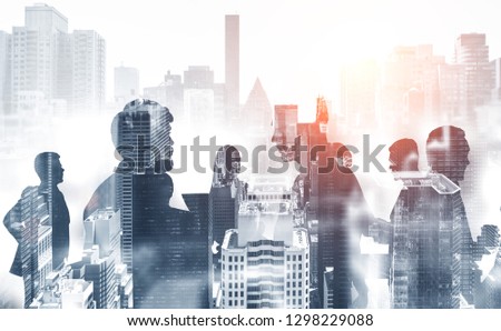 Silhouettes of business people communicating over gray cityscape background. Corporate lifestyle concept. Toned image double exposure