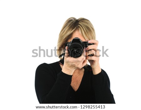 Beautiful middle aged woman taking a photo against a white background