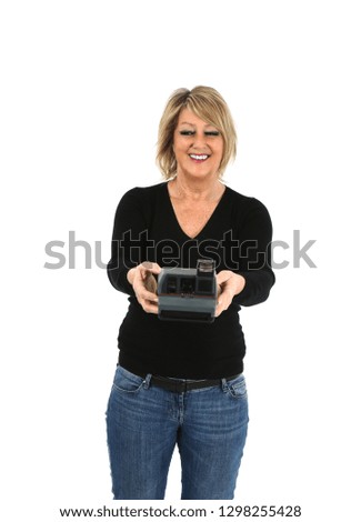 Happy middle aged woman smiling while holding a camera against a white background
