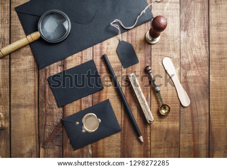 Photo of blank black stationery elements on vintage wood table background. Branding template. Mock-up for your design. Flat lay.
