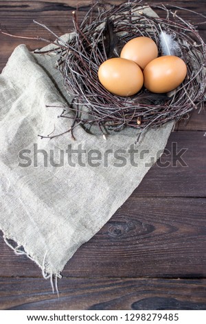 Golden easter eggs in birds nest on wooden background. Vintage style toned picture
