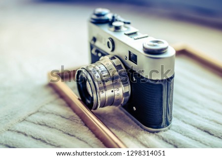 Old retro camera on vintage white board. Abstract background.