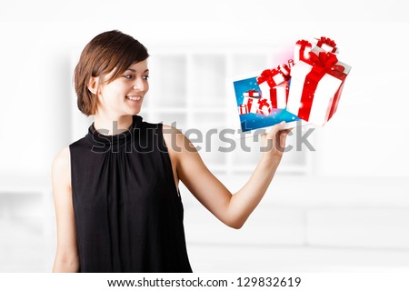 Young  woman looking at modern tablet with present boxes