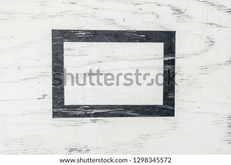 White painted wood board with a black frame in center grunge texture background.