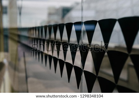 Black triangles on the glass wall. Decorative glass decoration. Stickers